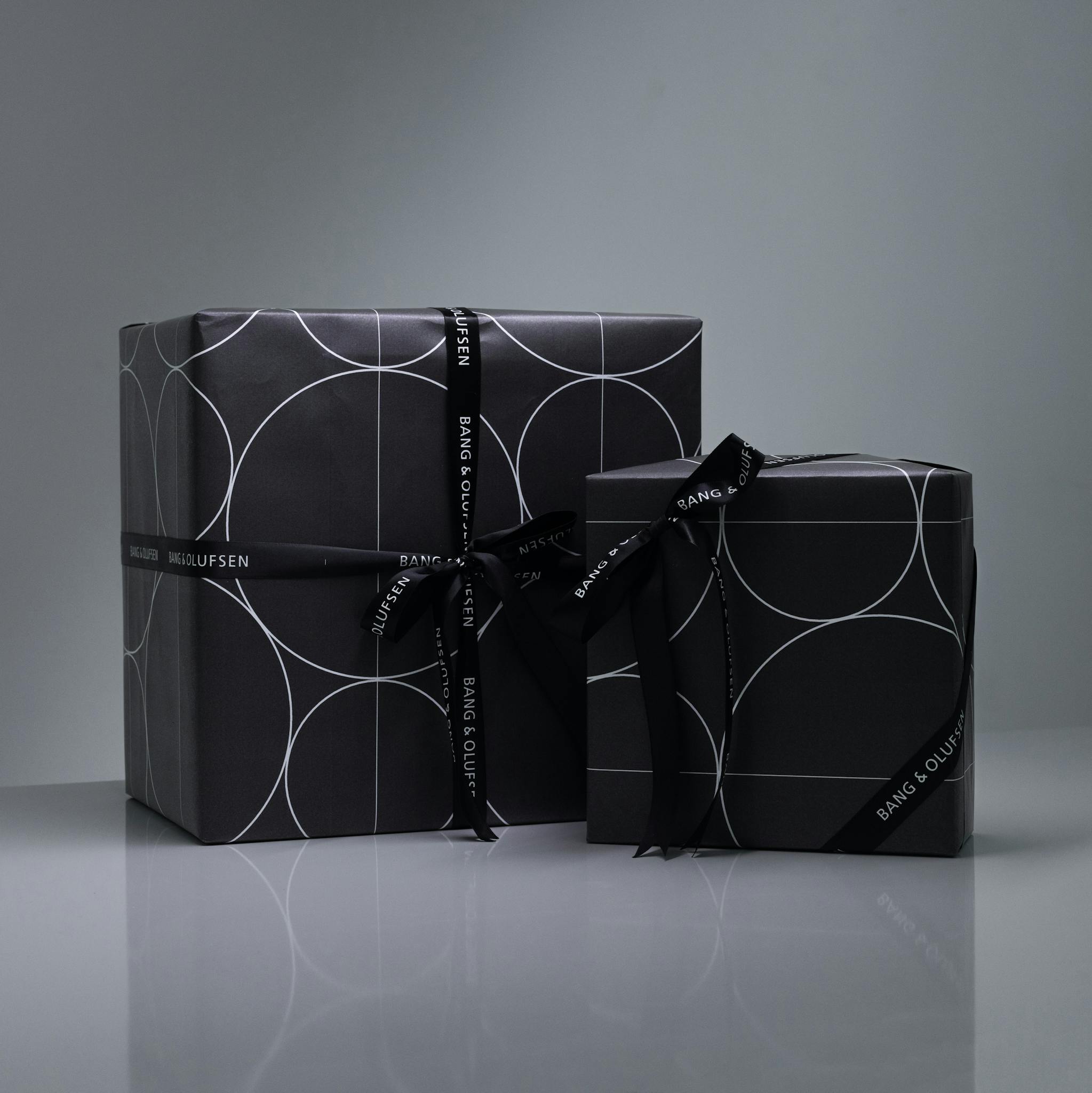 Elegant Bang & Olufsen wrapped gifts in minimalist style with dark tones and geometric patterns.