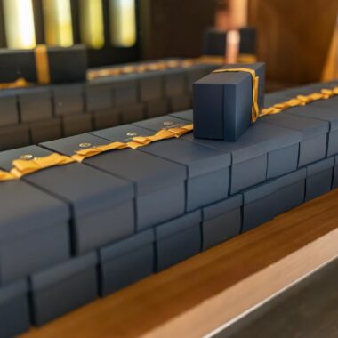 Elegant black gift boxes adorned with gold ribbons, perfect for luxury events or holiday celebrations.